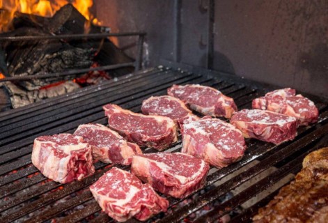 Cortes de carne bovina exibidos em um balcão de açougue, mostrando diferentes tipos de cortes prontos para venda